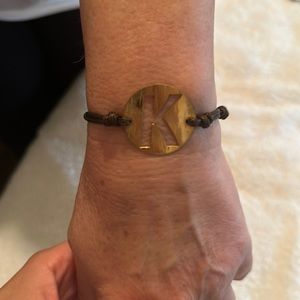 Leather band with gold plated letter K symbol bracelet.